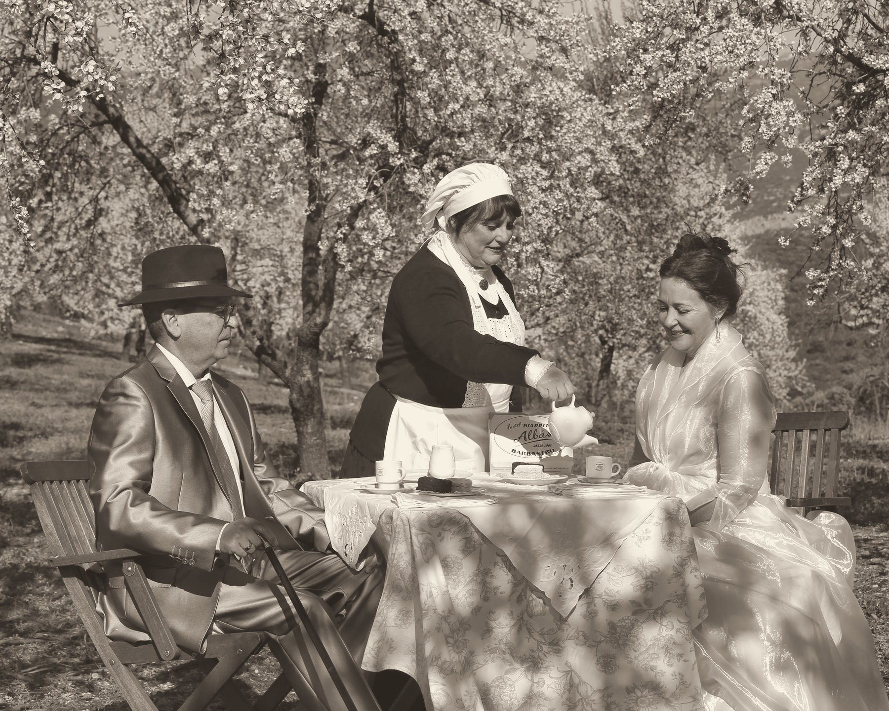 Merienda de época bajo los almendros en flor, en blanco y negro