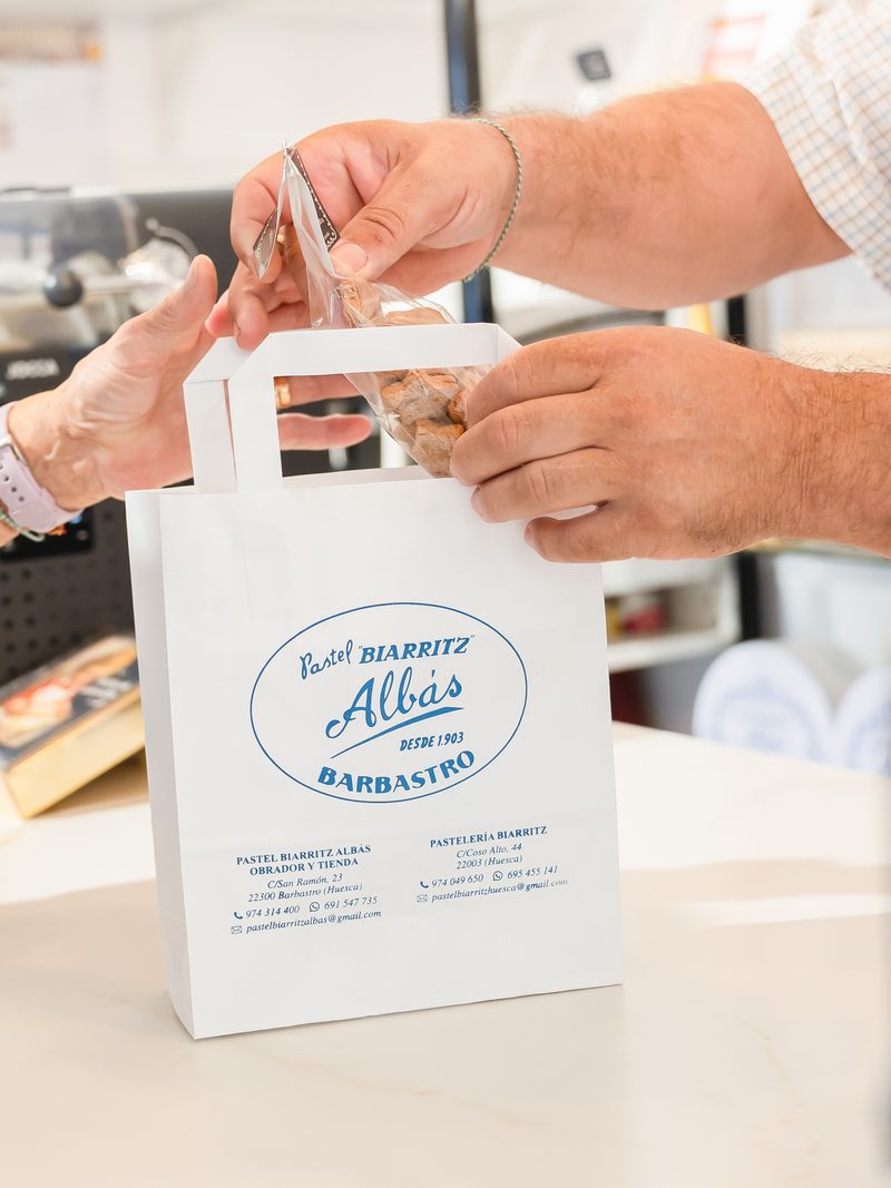 Entrega de una bolsa de Pastel Biarritz Albás en el mostrador