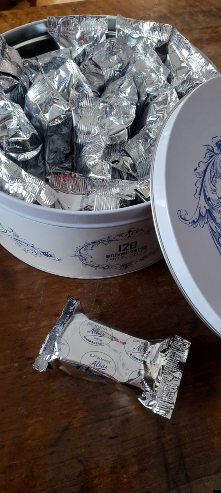 Lata del 120 aniversario abierta, llena de pasteles Biarritz envueltos uno a uno