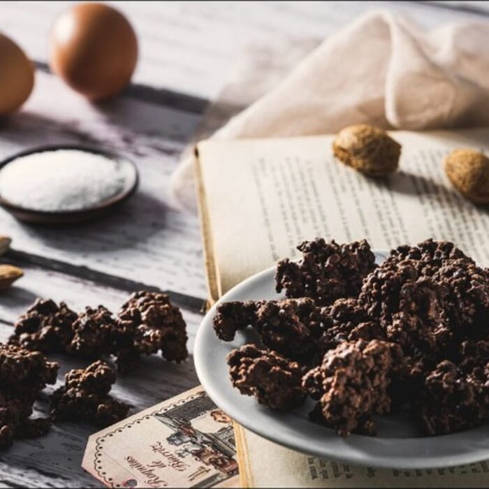 Roquitas de Biarritz en un plato, con almendras, huevos y azúcar sobre un libro antiguo